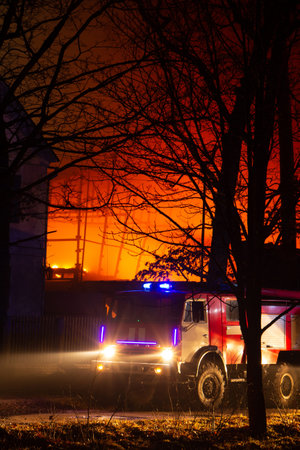 Fire in factory building at night. Burned by fire industrial warehouse.