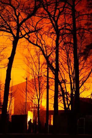 Fire in factory building at night. Burned by fire industrial warehouse.の写真素材