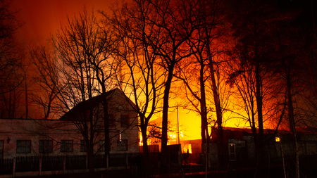 Fire in factory building at night. Burned by fire industrial warehouse.の写真素材