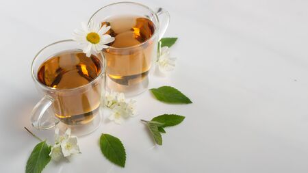 green tea with jasmine in a transparent glass thermomug on a white background close upの写真素材