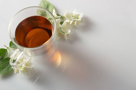 green tea with jasmine in a transparent glass thermomug on a white background close upの写真素材