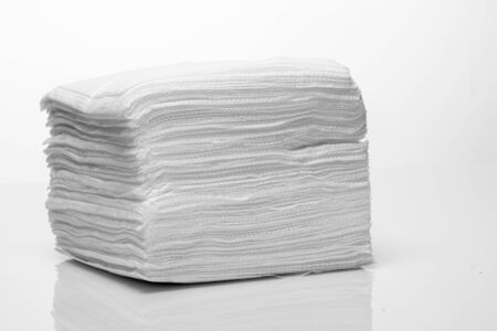 A stack of new white paper napkins on a white background close upの写真素材
