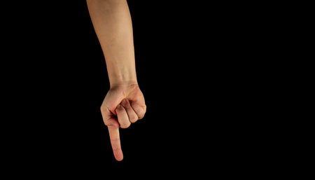 The hand of a young man on a black background close up