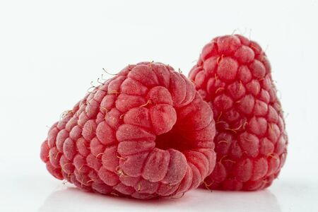 two ripe beautiful raspberry berry on a white background close upの写真素材