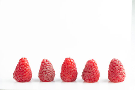 five ripe beautiful raspberry berry on a white background close up