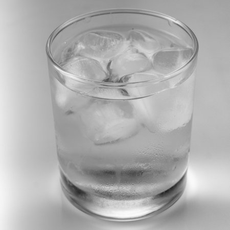 ice in a glass on a gray background close up