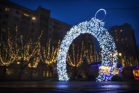 Defocus Christmas lights on the street arch with garlands in the shape of a Christmas ball.の写真素材