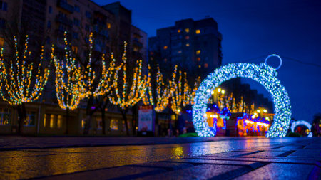 Defocus Street is decorated with garlands. Yellow lights on trees and an arch in the shape of a Christmas ball.の写真素材