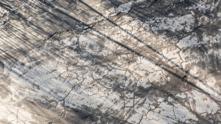 Large pits are filled with water on an asphalt road