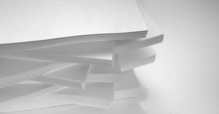 Several stacks of white paper on a white background