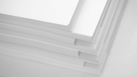 Several stacks of white paper on a white background