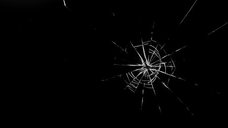 Round white cracks in glass on black background.