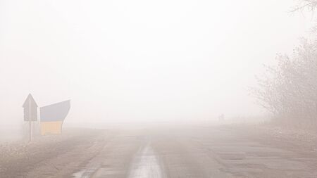 Autumn road in the fog. Limited visibility.の写真素材