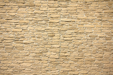 Stone wall texture, square yellow travertine tile. Design element or background.