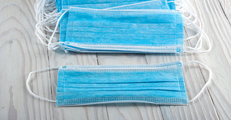 Protection concept from Coronavirus Protective blue medical mask on white wooden backgroundの写真素材