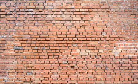 The brick wall has long been exposed to the aggressive environment. Deep seams. Old brick. Results of wind and rain erosion on bricks.の写真素材