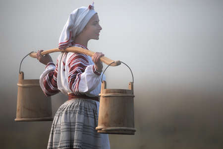 Embroidered shirt and buckets on the shoulders of a young attractive woman.の写真素材