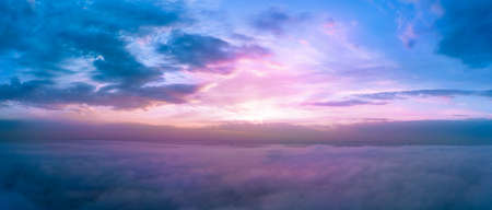 Dawn above the clouds, purple sunlight illuminates the morning sky.の写真素材