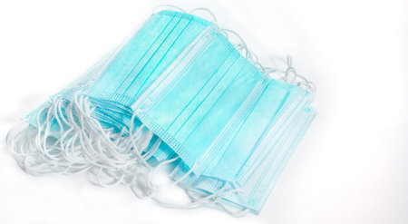 Big stack of green medical face mask with white rope strap for protective coronavirus COVID-19