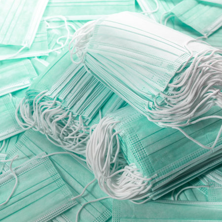 Medical disposable green mask, two stacks on a white background mask for protection against virusの写真素材