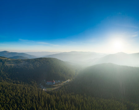 Wonderful dawn in the mountains, the sun's rays illuminate the mountain tops through the fog.の写真素材