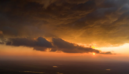 Sunrise or sunset. Summer landscape. The sun's rays shine through the storm clouds.