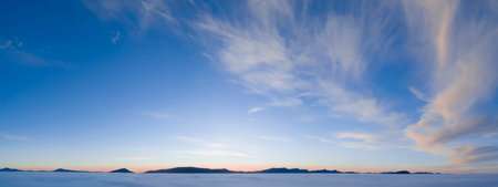 Picturesque sunset, panorama. The sun's rays illuminate the clouds in warm, pink and purple colors.
