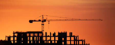 Construction cranes at dawn in the morning mist.の写真素材