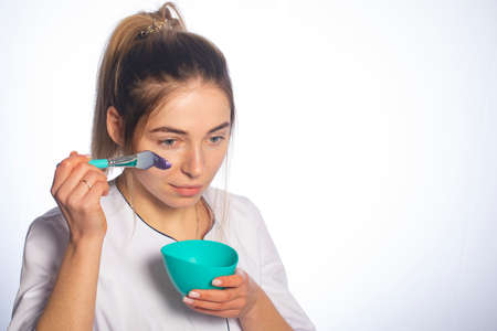 Woman applies a cosmetic mask on her face.の写真素材