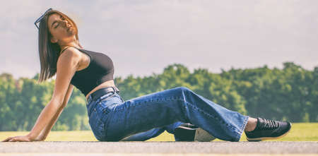 Young attractive girl sitting on the asphaltの写真素材
