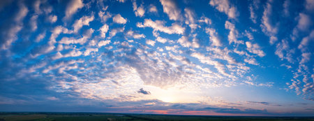 Panorama of the morning blue sky, illuminated by orange and red sunlight, colorful dawn.の写真素材