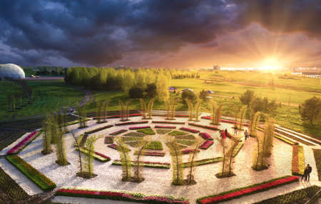 Wonderful summer landscape. Round flowerbed with blooming tulips at sunrise in the park. A great place for meditation. and yoga classes.の写真素材