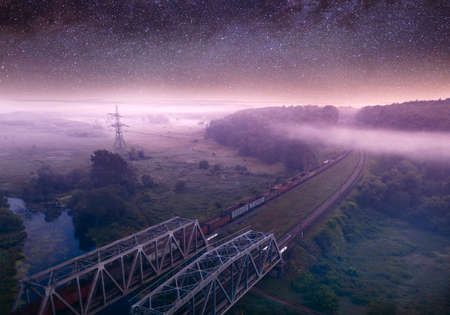 Summer night landscape, railway through the forest. Starry sky.の写真素材