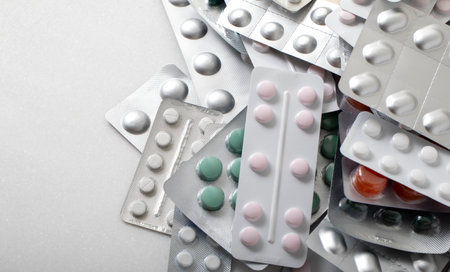 Plates with pills and capsules on a white background with space for text. Bannerの写真素材