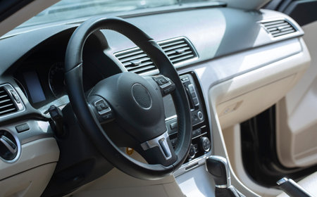 Modern car interior. The driver's seat is decorated with white and black leather and metal. Modern...