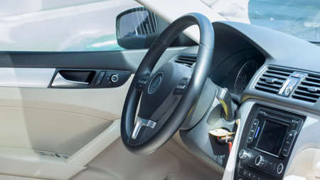Modern car interior. The driver's seat is decorated with white and black leather and metal. Modern electronic devices on the car panel.の写真素材