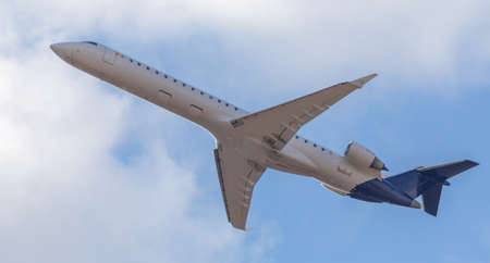 A commercial passenger plane operates a flight to carry passengers. Bottom view on sky background.の写真素材