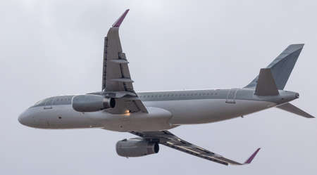 A commercial passenger plane operates a flight to carry passengers. Bottom view on sky background.の写真素材