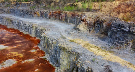 Large granite quarry with gray stone. Red water at the bottom of the quarry. Iron Ore.の写真素材