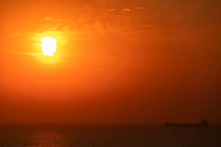Bright crimson sun on a background of sunset or dawnの写真素材