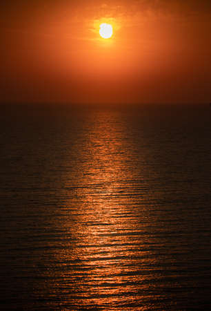 Bright red sunset over the sea and the beach, close-up. Thailand.の写真素材