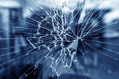 Cracks in the window. Bullet hole in the glass. Isolated on a black background.の写真素材