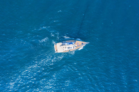 Aerial view of a boat or yacht on the ocean surface. Summer vacation at sea. Rent of sea vessels, for active rest. Water sports.の写真素材