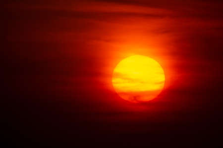 Bright crimson sun on a background of sunset or dawnの写真素材