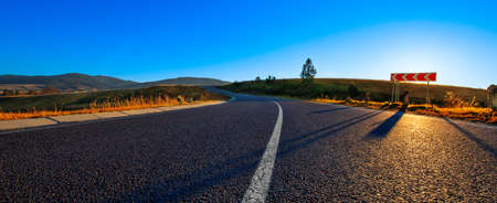 Paved road in the mountains. Autumn landscape at sunset.の写真素材