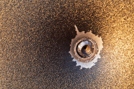 The bullet is stuck in a piece of sheet metal. Macro.