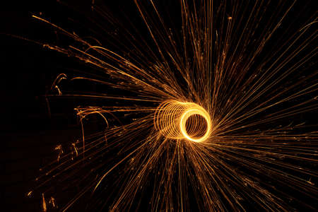 Night fire dance. Sparks from steel wool on a black background. Close-up.の写真素材