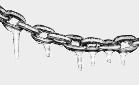 Icicles on a chain, frosted metal on a light background.の写真素材