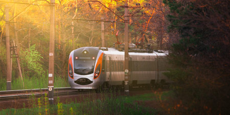 A large passenger train is heading in the direction of dawn. Place for text, concept, travel.