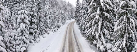 Aerial view of a curved mountain road Aerial view of a curved mountain road in Europe. winter mountain landscape. Snow-covered trees and mountain slopes. Drone view.Europe.の写真素材